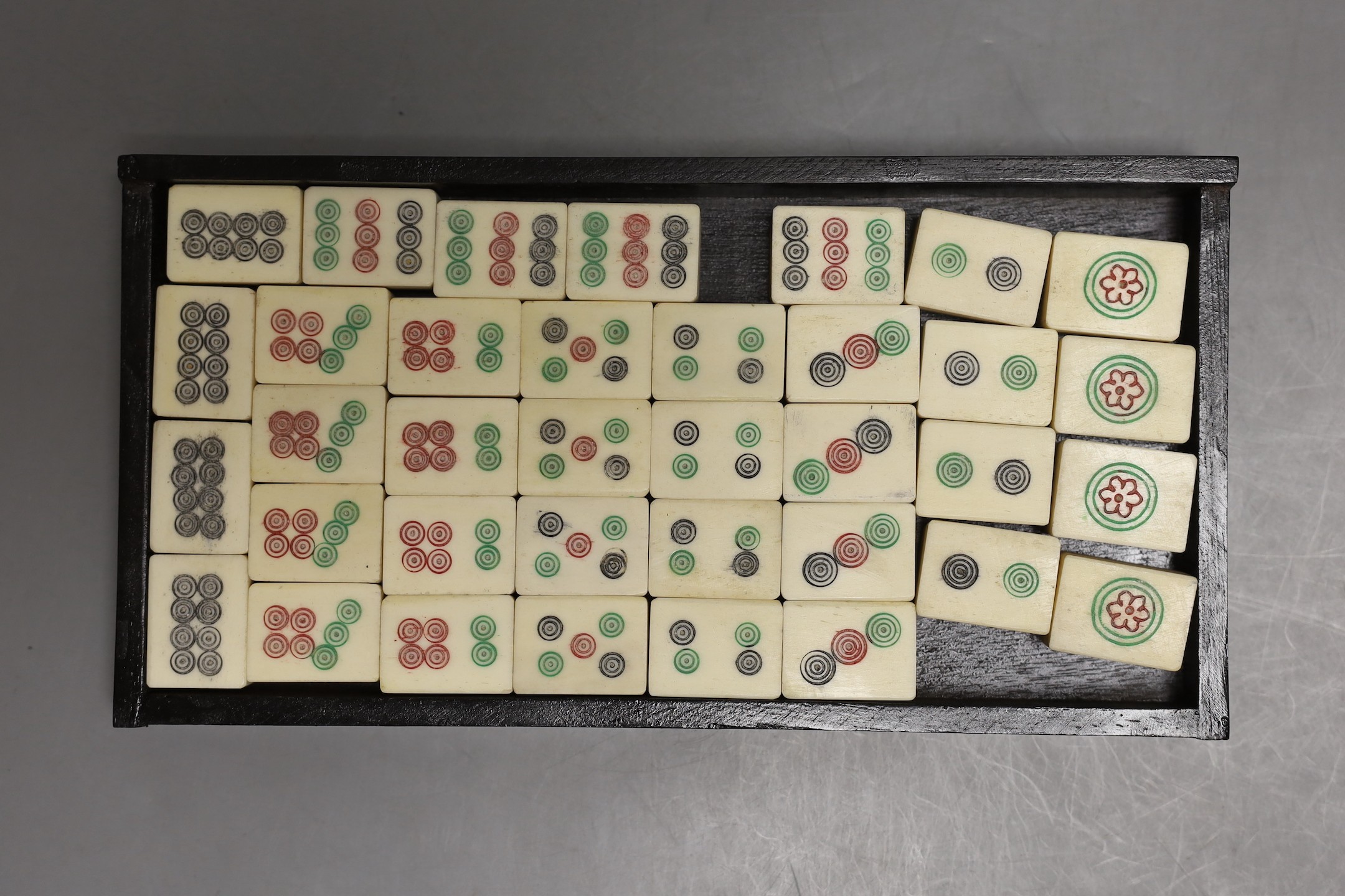 A Chinese boxed mahjong set, bone and bamboo gaming pieces, 24.5 cms wide x 16cms high.
